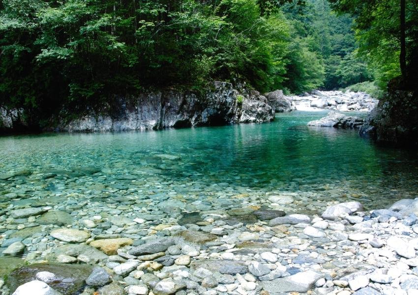 The clear, pebble-bottomed Atera River winding between forested banks