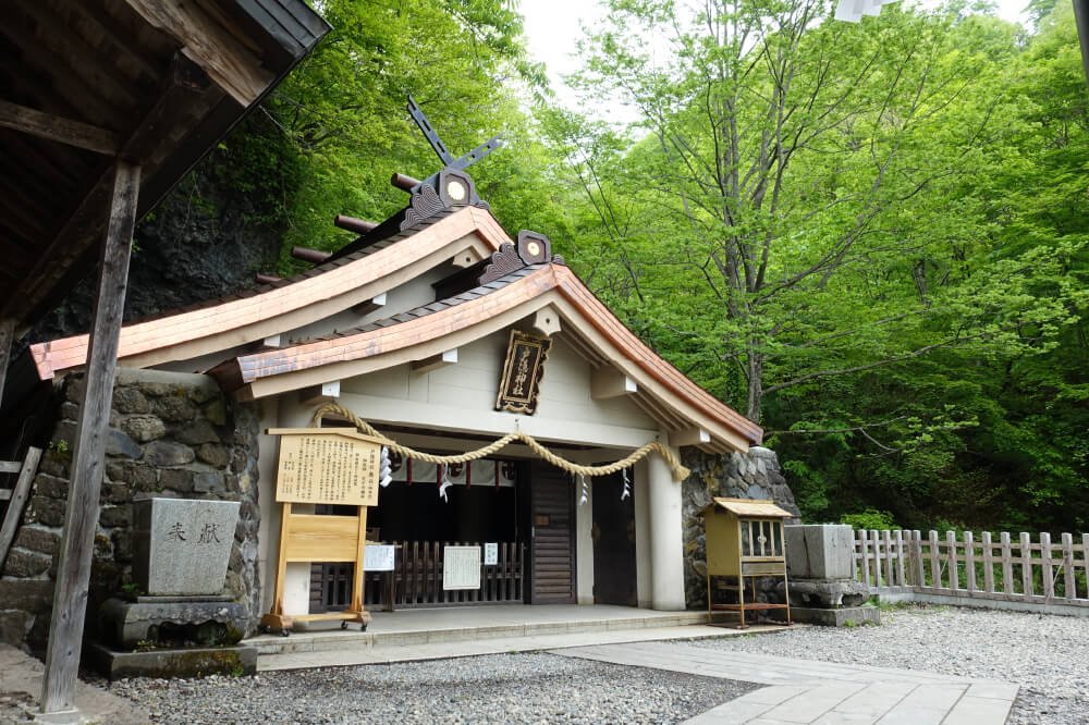 Okusha Shrine's hall set against the cliffs at the foot of Mt. Togakushi