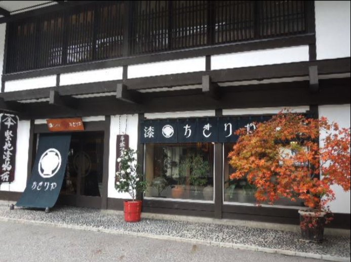 The traditional storefront of Chikiriya Tezuka Man'emon Lacquerware Shop, with a maple tree out front
